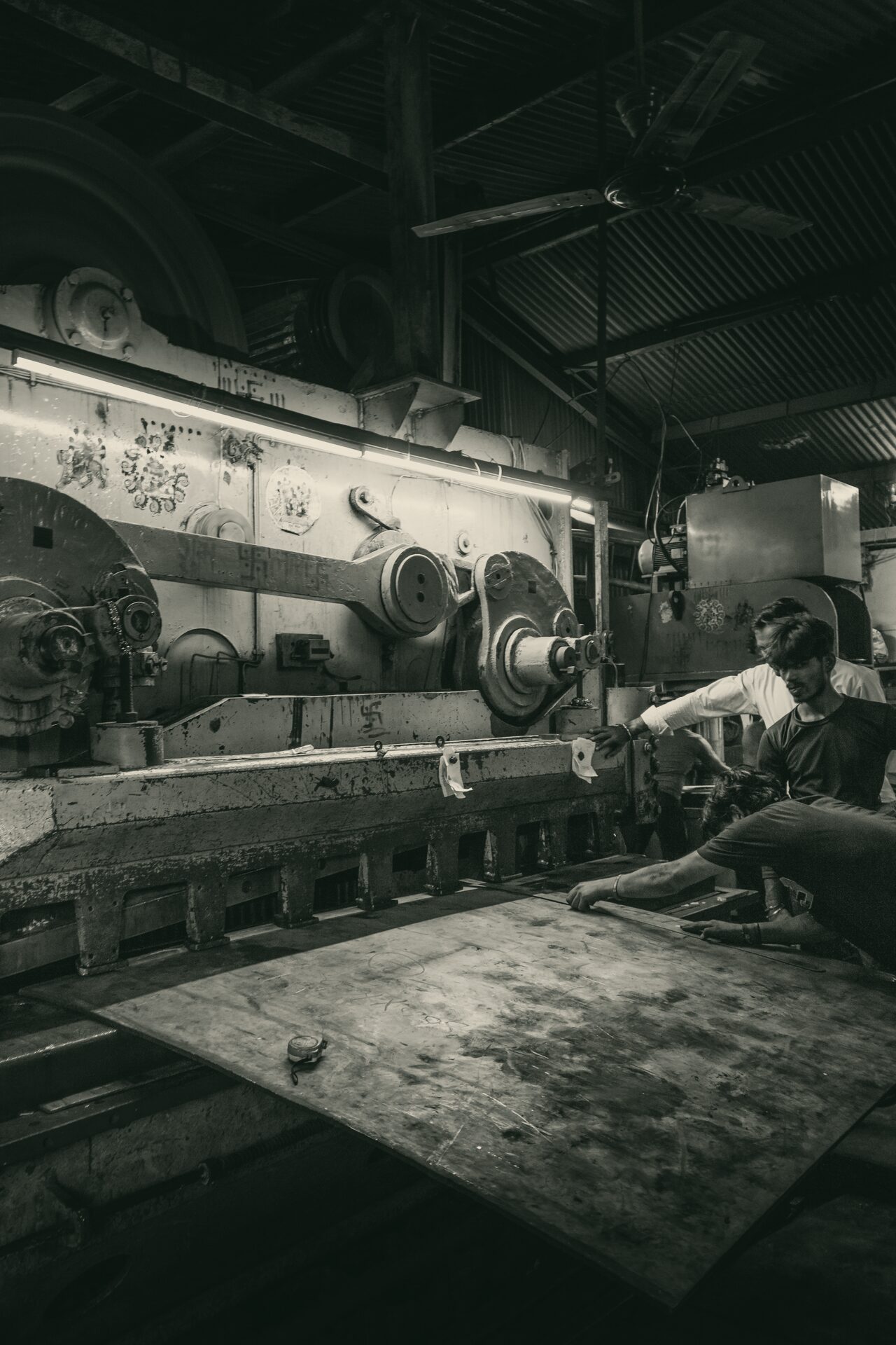 A worker at a press on a factory production line