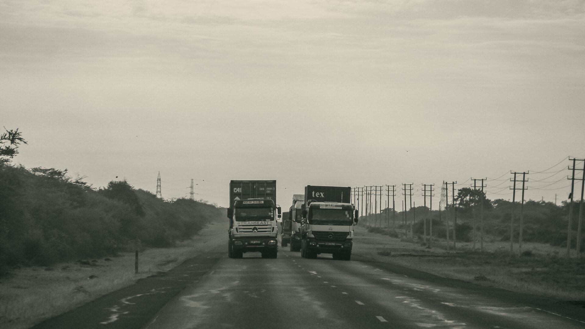 Freight trucks on an open highway at dusk