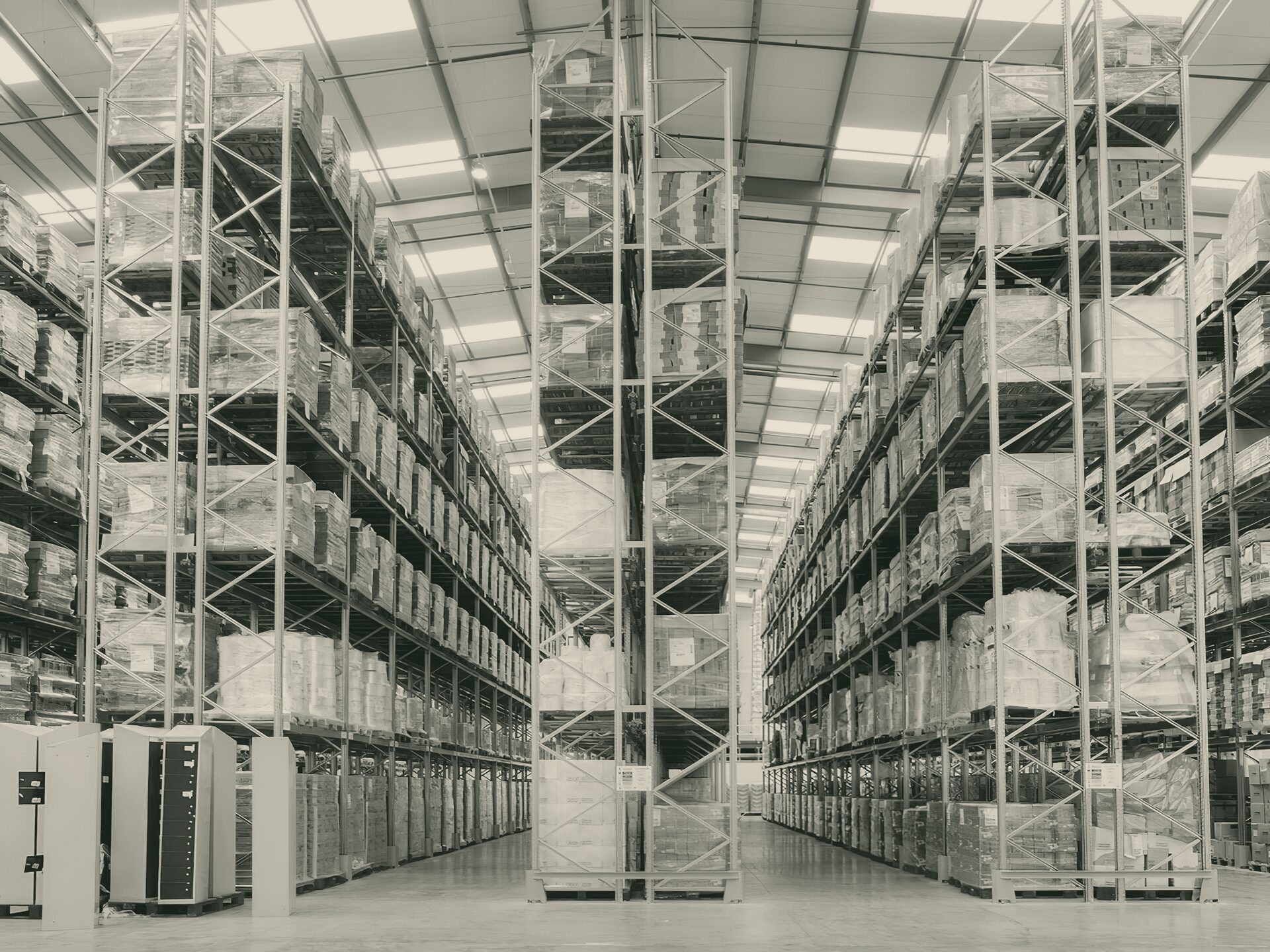 A warehouse aisle lined with pallet racking stacked to the roof